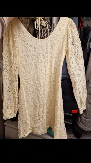 Ny gul spetsklänning med etikett - Söt gul spetsklänning med puffiga långa ärmar och rundad urringning. Klänningen har knytband i nacken och är helfodrad under spetsen. Perfekt för dig som gillar romantisk och bohemisk stil. Perfekt till våren, påsken och sommaren till solbrända ben och rygg. Svårt fota nyansen gul men se sista bild. Etikett säger cream men jag skulle säga gul.
