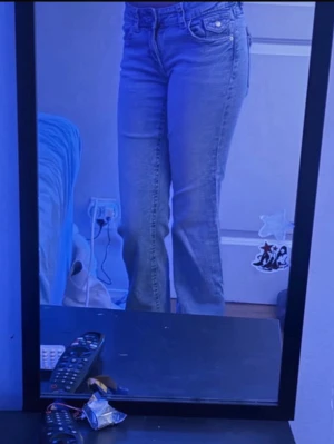 Ljusblå jeans med fickor - Säljer ett par ljusblå jeans med raka ben och klassisk femficksmodell. Jeansen har normal midja och snygga detaljer på bakfickorna. Perfekta till en avslappnad stil och passar till det mesta. Inget synligt märke på jeansen.
