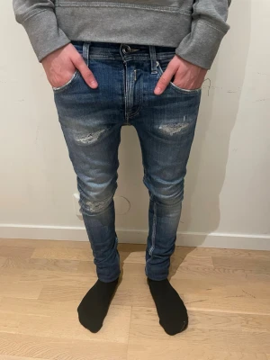Blå slitna skinny jeans - Säljer ett par lite schysstare blå replay jeans men slitningar. Modellen är 170cm. Hör av dig för mer information 