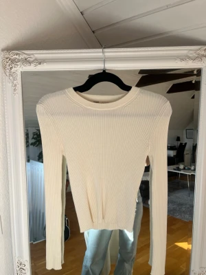 Vit ribbad tröja från Pull&Bear - Säljer en stilren vit ribbad tröja från Pull&Bear. Tröjan har rund halsringning, långa ärmar och är figurnära i modellen. Perfekt att matcha med jeans eller kjol för en clean look. Skulle säga att det är en mer Xs är M 