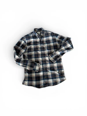 Flanell skjorta - Klassisk rutig skjorta i blått och vitt från Lindex. Skjortan har långa ärmar, knappar framtill och en avslappnad passform. Perfekt för en chill och stilren look. Tillverkad i mjuk bomull som känns skön mot huden.