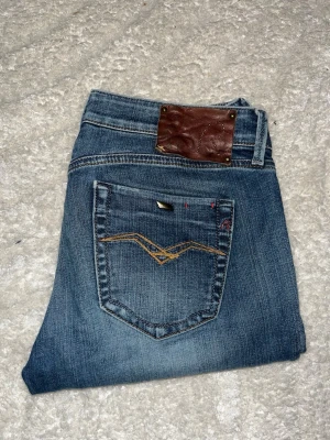 Repaly jeans  - Replay jeans i blå tvätt med raka ben. Midja 39cm, längd 98cm. Obs storlekslapp saknas men jag skulle bedöma till W29 L30 - men utgå alltid efter angivna mått. JAG SKICKAR EJ FLER BILDER NÄR JAG BÄR JEANSEN! för bättre inblick i passformen rekommenderar jag att googla på modellnamnet. För storleksguide kolla måtten noggrant då jeansen alltid kan vara uppsydda heller krympta och jag ej tar emot returer :) s6,5
