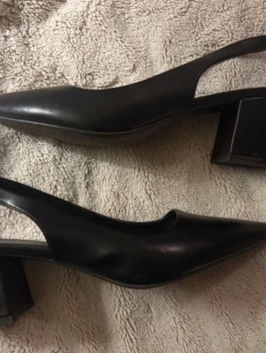 Slingback, strl 41 - Svarta slingback/pumps/klackskor från XIT. Storlek 41. 7.5 cm.