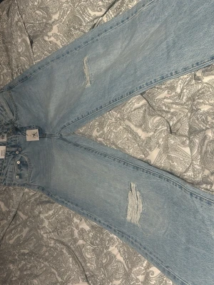 Ljusblåa vida jeans med slitningar - Säljer ett par ljusblåa jeans från lager 157, köpte för orginal pris 300 då jag säljer dom för 170. Aldrig använt dom då prislapp och allt sitter kvar.