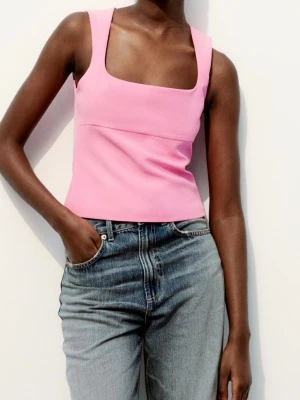 Rosa topp med breda axelband från Zara - Trendig rosa topp från Zara med breda axelband och fyrkantig urringning. Toppen är figurnära och har en stilren, minimalistisk design. Sprillans med lappen kvar. Den har dock en liten tråd lös som synd på bilden. 