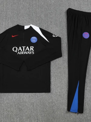 Svart PSG träningsset från Nike- M junior - Snyggt svart träningsset från PSG och Nike med långärmad tröja och matchande byxor. Tröjan har vita och blå detaljer, PSG-logga, Qatar Airways-tryck och röd Nike-swoosh. Byxorna har blå detalj och PSG-märke. Perfekt för fotbollsträning eller chill.