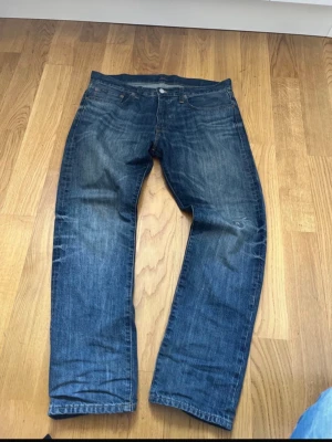 Blå raka jeans från Polo Ralph Lauren - Säljer ett par klassiska blå jeans från Polo Ralph Lauren med rak passform och fem fickor. Jeansen har snygga slitningar och en mörk tvätt, perfekt till en avslappnad stil. Materialet är denim i bomull. kom dm för frågor 