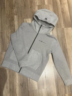Grå hoodie från Sail Racing - Snygg grå hoodie från Sail Racing med dragkedja framtill, två stora fickor och logga på bröstet. Mjuk och skön. Inga prisförslag är dumma!