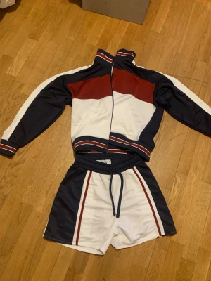 Retro träningsset i marinblått och vitt - Snyggt retro träningsset från Bershka. Perfekt för sport eller chill. Tröjan använd 1 gång och shortsen nya med tags. 200kr/st elr hela för 300kr