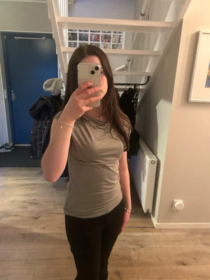 Olivgrön topp med korta ärmar - Säljer en olivgrön topp från Lager157 med korta ärmar och rund halsringning. Toppen är figurnära och tillverkad i mjuk bomull, perfekt för en enkel och stilren look.