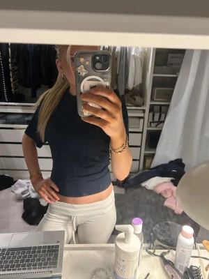 Mörkblå croppad t-shirt - Snygg mörkblå croppad t-shirt med korta ärmar och rund halsringning. Perfekt till jeans eller mjukisbyxor för en avslappnad och trendig look.