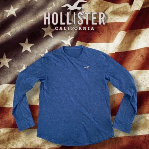 Blå långärmad tröja från Hollister - Säljer en riktigt schysst långärmad T-shirt från Holliser i storlek M🙌🏻|| skick 9/10 || Modellen på bilden är 183cm ||Hör av er vid frågor!!💫