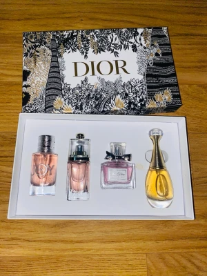 Dior parfymset med fyra miniflaskor 4x30ml - Lyxigt parfymset från Dior med fyra miniflaskor i olika former och färger. Setet innehåller klassiska dofter i eleganta glasflaskor, levereras i en vacker presentask med guld- och svartmönster. Perfekt för dig som vill testa flera Dior-parfymer.