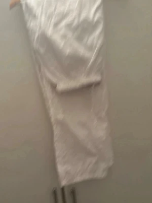 Vita vida linnebyxor - Säljer ett par vita linnebyxor med rak och avslappnad passform. Byxorna har resår i midjan och är tillverkade i ett lätt och luftigt material, perfekt för varma dagar. Klassisk och enkel design utan synliga detaljer eller fickor. För mer bilder/information skriv gärna🤗❤️ (köptes utomlands)