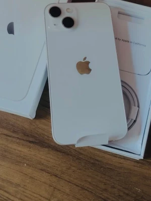 Vit iPhone med dubbla kameror - Snygg vit iPhone med stilren design, två stora kameralinser och klassisk Apple-logga i silver på baksidan. Mobilen har rundade hörn och glasbaksida. Levereras med originalkartong och laddkabel. Perfekt för dig som gillar modern teknik och enkelhet.