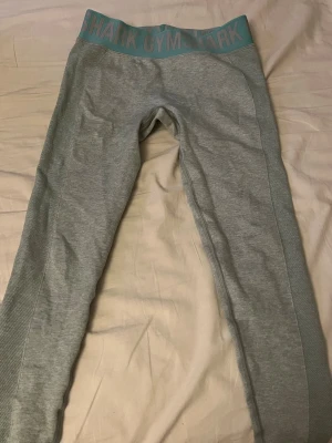 Gymshark träningstights  - Grön/blåa träningstights från gymshark tror de är storlek S för har ett par lika dana i annan färg med lappen i, de känns liknande i storleken. 