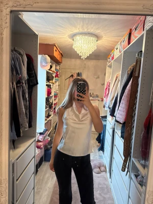 Vit ärmlös satintopp med draperad krage - En vit ärmlös topp i satinliknande material. Har snörning som knyts i nacken💕