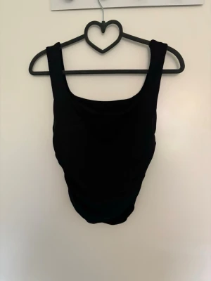 Svart croppad linne - En stilrent svart linne med breda axelband och rundad urringning. Materialet är stretchigt och skönt att ha på sig. Enkel och tidlös design som passar till alla tillfällen. Finns likadan fast i vit på min profil.