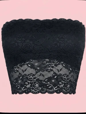 Svart spets bandeau tubtopp - Säljer en svart bandeau tubtopp i spets med blommigt mönster och vågig kant nertill. Toppen är ärmlös och har en snygg, feminin look som passar perfekt till lager-på-lager eller som statement-piece. Superstretchig och bekväm att bära.
