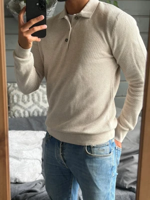 Pikétröja - Snygg beige pikétröja med diskret struktur från Bläck i storlek S. Passar dig mellan 170-180cm. Funkar perfekt nu till sommaren då den är luftig i materialet. Inga defekter! Bara att kontakta vid funderingar!🌟