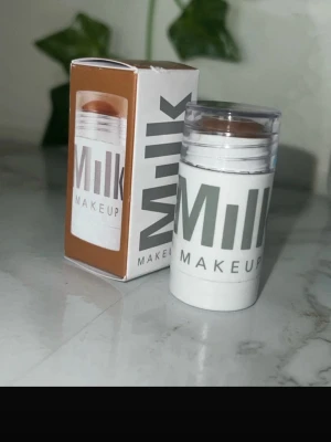 Milk Makeup bronzer stick - Krämig bronzer i stickformat från Milk Makeup. Färgen är varm brun med naturlig finish, perfekt för att skapa solkysst look. Kommer i en smidig vit plastförpackning med genomskinligt lock och tydlig logga. Enkel att applicera och blenda.