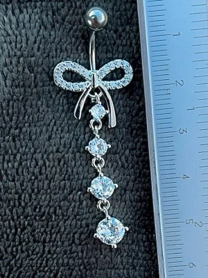 NY oanvänd Navelpiercing med hänge | Kirurgiskt stål | Rosett och vita stenar  - 💕30% Bundle-rabatt vid köp av minst 2 artiklar. ⭐️NY oanvänd piercing i kirurgiskt stål; rostfritt och säkert för läkta piercingar.                               📏MÅTT ⭕️Stavens längd: 10mm ⭕️Stavens tjocklek: 1,6mm ⭕️Smyckets totala längd: 50mm                                                                         🤍Färger: Silver och vit                                                            💌Skickas spårbart via Plick SafePay.