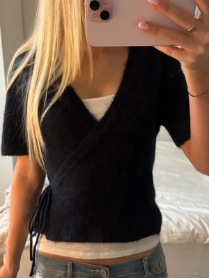 Mörkblå stickad tröja - Mörkblå stickad omlottopp med snörning, endast använd ett fåtal gånger och nyskick! Gjord i Gina Tricot’s sköna Wool blend som inte ska noppra!