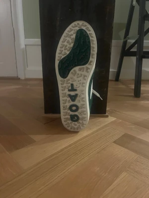 Goatlane gröna och vita golfskor - Sneakers från Goatlane i vitt och grönt läder med vit sula och vita snören. Klassisk låg modell med tydlig logga på sidan och under sulan. Snygg kontrast mellan färgerna och en clean, sportig vibe.