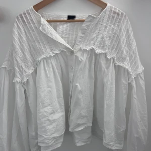 Vit volangblus med knappar - Superfin vit blus med volangdetaljer och knappar framtill. Blusen har breda, långa ärmar och knappar nere vid handen med💕 pris går att diskuteras!!