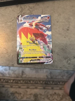 Pokémonkort Blaziken VMAX - Säljer ett Pokémonkort Blaziken VMAX Rapid Strike med 320 HP. Kortet har färgstark design med röd, gul och blå bakgrund och visar Blaziken i action. Perfekt för samlare eller Pokémonfans som vill utöka sin kortlek. Pris inte skrivet o Sten går o diskuteras 