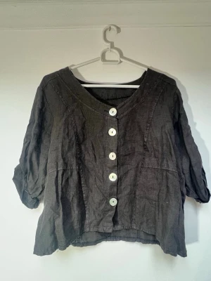 Mörkbrun blus - Mörkbrun blus, i storlek XL men är liten i storlek och passar nog bättre som M🌻 - Stora knappar framtill, på ärmarna och en på ryggen - Ärmarna är i armbågslängd - Okänt märke - 100% Linne