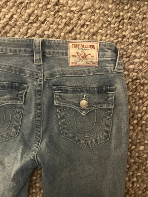  True Religion jeans  - Säljer ett par ljusblå bootcut jeans från True Religion. Midjemåttet: 38 cm Innerbenslängd:81cm 💋