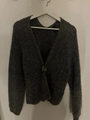 Mörkgrå kofta - Mysig mörkgrå kofta med djup V-ringning. Långärmad och rak passform.