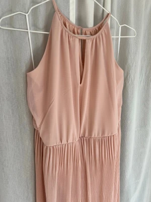 Ljusrosa långklänning med plisserad kjol - Jag säljer en jättefin ljusrosa balklänning i nyskick. Har aldrig kommit till användning och är i storlek 36.🩷 (Knytningen kan man välja om man vill ha den fram eller bak)