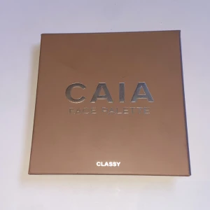 CAIA Face Palette Classy - Säljer en CAIA Face Palette i färgen Classy. Paletten innehåller contour, bronzer, blush och highlighter i varma toner. Förpackningen är fyrkantig i beige med spegel på insidan. Perfekt för att skapa en fräsch bas med både matta och skimrande nyanser. Fick i julklapp, nästan aldrig använd. 