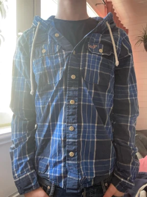 Blårutig skjorta med huva Hollister - Säljer denna skjort hoodien från Hollister. Modellen är 174|65kg har storlek S. Skriv vid frågor💫