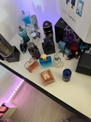 Olika parfymer  - Riad Souk Extrait de Parfum är en lyxig parfym i en stilren, fyrkantig glasflaska med blå till transparent färg och guldfärgad kork. Flaskan rymmer 50 ml och har elegant guldtext på framsidan. Perfekt för dig som gillar exklusiva dofter och snygg design.