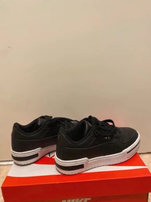 Svarta Puma sneakers med vit sula - Snygga svarta sneakers från Puma med vit, chunky sula och gulddetaljer på plösen och sidan. 