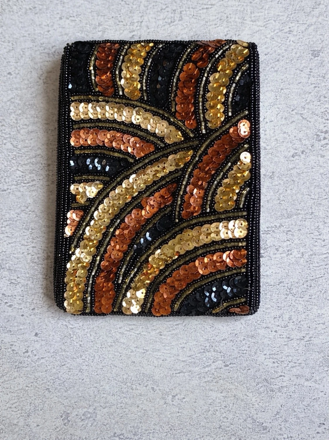 Kuvertväska med paljetter i guld och svart