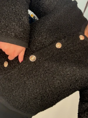 Svart kofta med guldknappar - Säljer en svart, fluffig kofta/jacka från Gina Tricot i storlek M