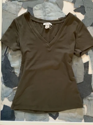 Mörkgrön v-ringad - Snygg mörkgrön t-shirt från newyorker med v-ringning och korta ärmar. perfekt till jeans eller kjol.skön mot huden. använd 1 gång 