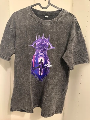 Solo Leveling T-shirt – washed svart (M/L) - Snygg svart/grå “washed” T-shirt med tryck inspirerat av Solo Leveling. Motivet ger en mörk och kraftfull vibe som passar perfekt för dig som gillar anime och streetwear.  Detaljer: 	•	Anime-inspirerat tryck framtill 	•	Washed/vintage-look 	•	Klassisk passform 	•	Rund hals 	•	Korta ärmar 	•	Bekväm och mjuk  Storlek: Passar M–L  Perfekt att matcha med jeans eller cargos för en clean streetwear-look.  💬 Hör av dig vid intresse!
