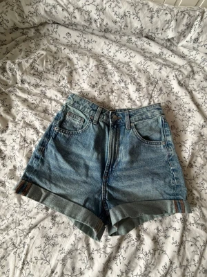 Högmidjade jeansshorts - Säljer ett par jeansshorts med hög midja och uppvikta benslut. Shortsen har femficksdesign och en cool tvätt. Perfekta för varma dagar och enkel att matcha. Passar mig som har strl s och vanligtvis 34:a? Om du har frågor eller vill ha mått eller fler bilder tveka inte att fråga mig! 💗Pris kan diskuteras.