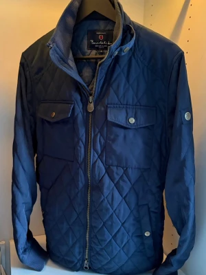 Marinblå quiltad Field jacket - Snygg marinblå quiltad field jacka från Bondelid. Perfekt för kyliga dagar och en snygg look. Storlek S, Skick 8/10
