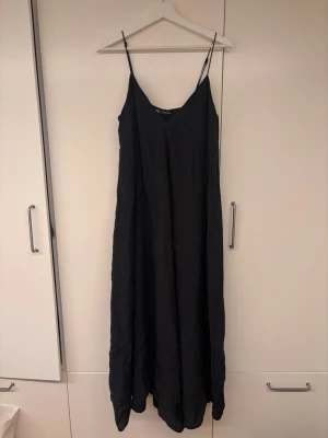 Zara klänning  - Lång svart klänning från Zara. Nästan aldig använd, mycket bra skick. Storlek S. Går att spänna åt. 