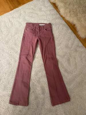 Rosa bootcut jeans  - Säljer ett par snygga rosa bootcut jeans. Jeansen har klassisk femficksmodell, normal midja och utsvängda ben. Materialet är mjukt och stretchigt för skön passform. Perfekta för dig som vill ha en unik färg på dina jeans!