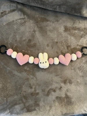Virkat barnvagnshänge  - Virkad barnvagnshänge med rosa och vita hjärtan och bollar💞