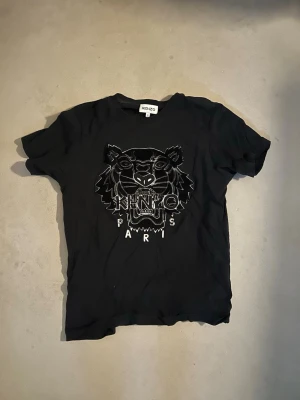 Kenzo t-shirt - Black on black kenzo t-shirt, i storlek S. Tröjan är i bra skick, loggan är lite sliten. Köpt i Las Vegas. Industrie tag är korrekt. 