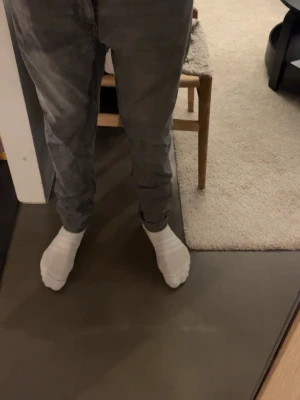 Grå slim fit Levi’s jeans - Säljer ett par grå slim fit jeans med klassisk femficksdesign och normal midja. Jeansen har en snygg tvättad look och smal passform som sitter tajt längs benen. Perfekta för dig som gillar en modern och enkel stil.