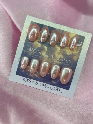 Satin (XS); Short Almond - Snygga press-on naglar från Vonjua Nails i en skimrande pärlemorrosa färg. Naglarna har en oval form och dekoreras med en liten swirl-detalj vid nagelbandet. Perfekt för dig som vill ha ett trendigt och elegant nagelset. Materialet är plast.